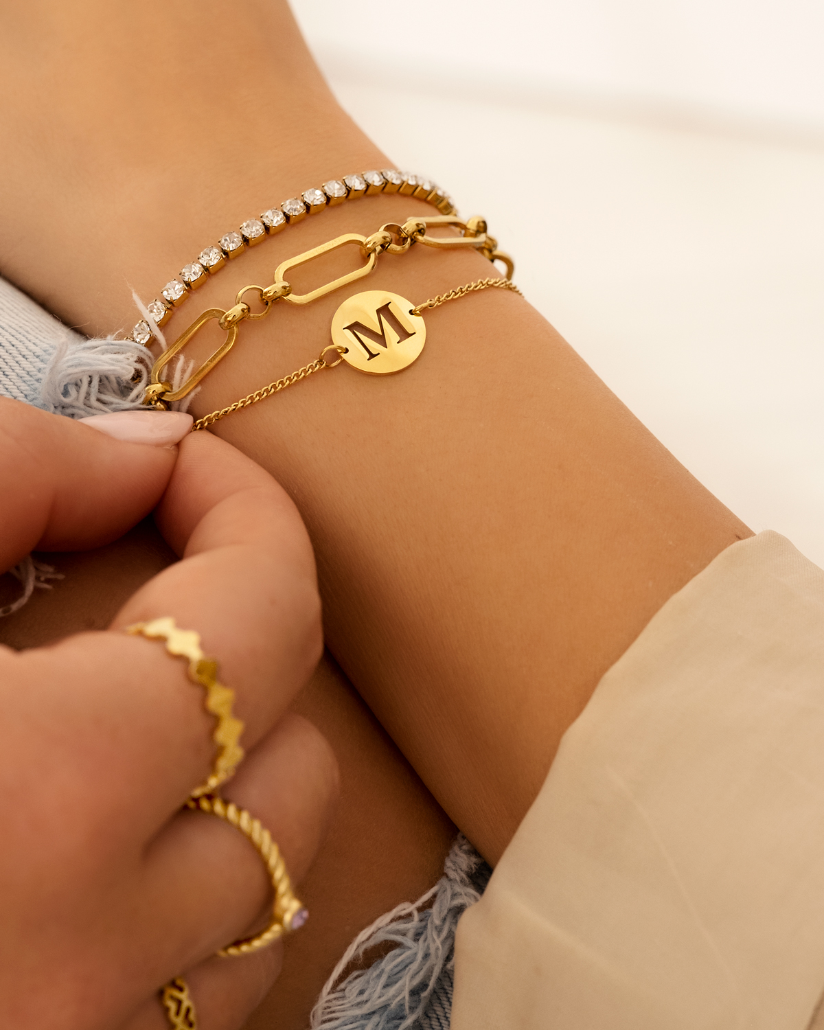 Gouden armparty met tennis en initials