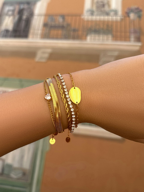 Graveerbare armband charm goud kleurig gedragen om pols