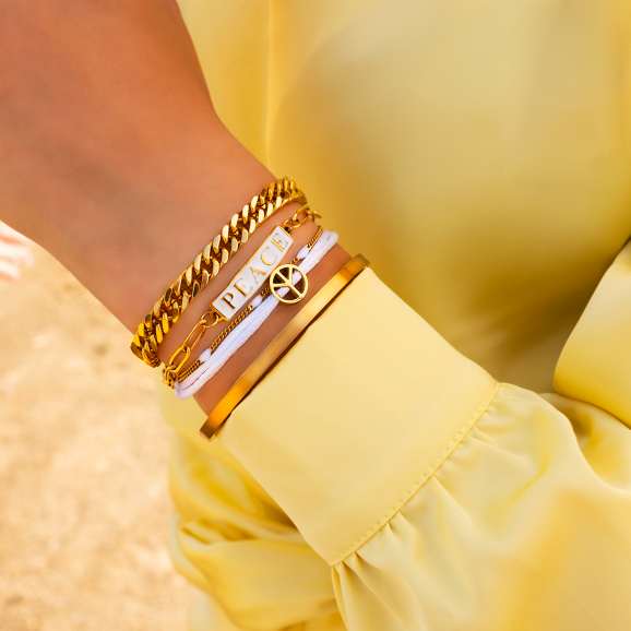 Gouden mix van armbanden met gele blouse