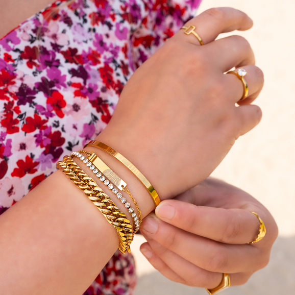 Vrouw draagt combinatie van mooie gouden armbanden