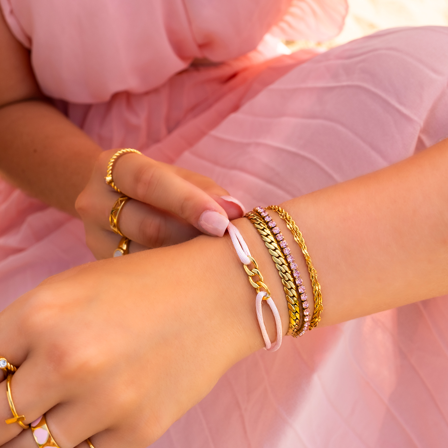 Armparty met gouden en roze armbanden om pols