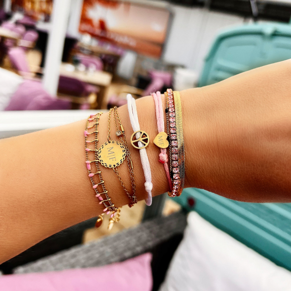 Roze armbandjes gecombineerd met gouden armbanden