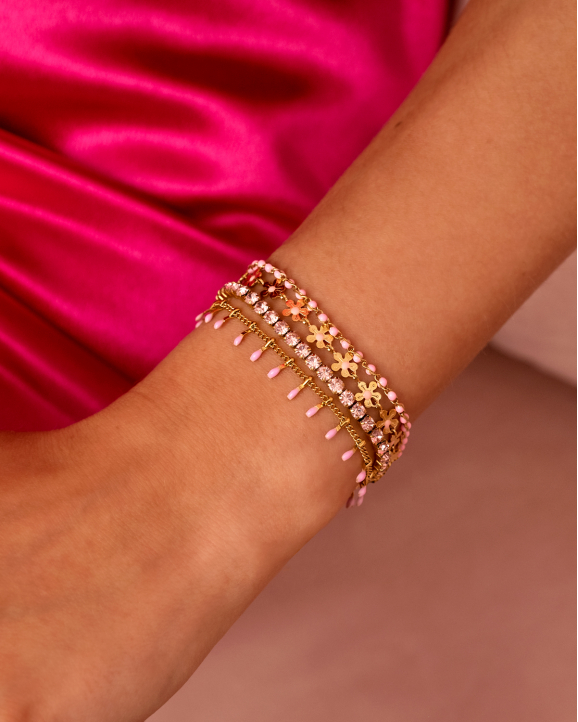 Gouden armparty met roze details om arm