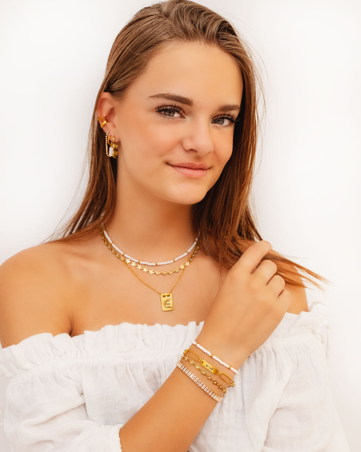 Gouden zomerse sieraden look bij meisje met bruin haar 