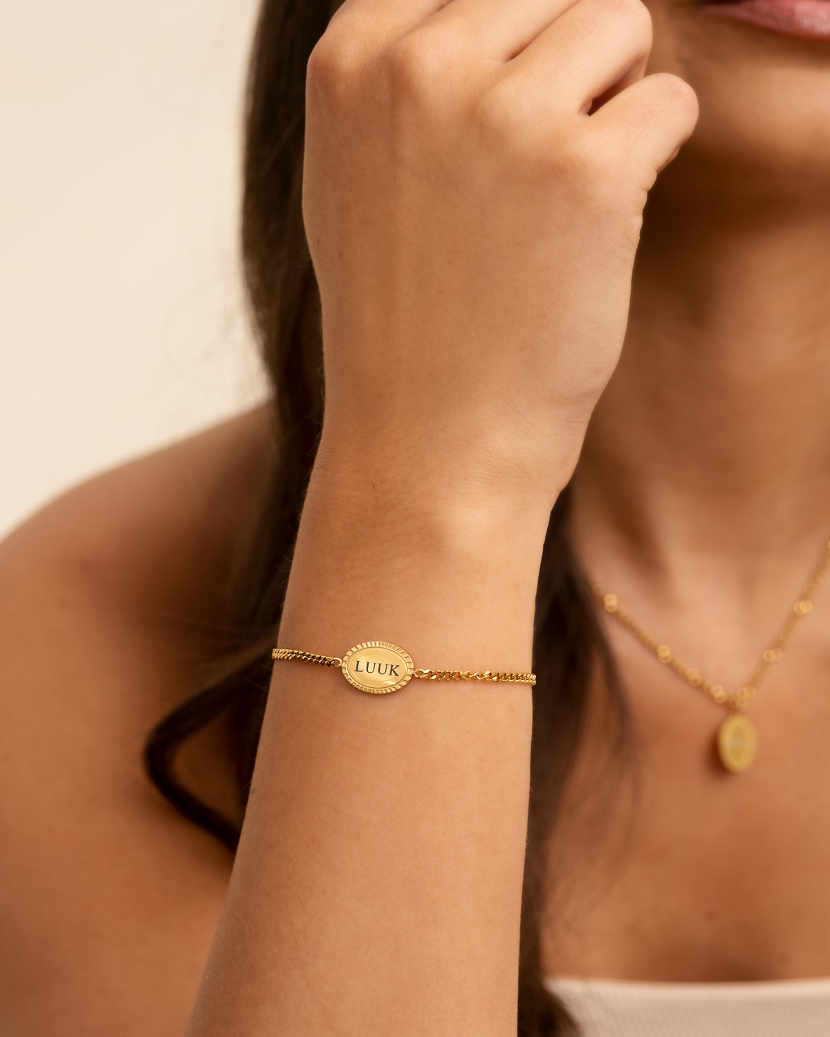 Model draagt graveerbare armband in het goud