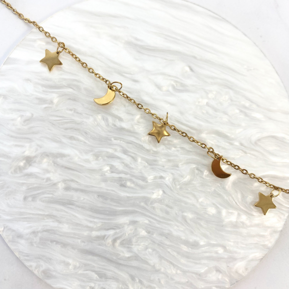 Trendy armband met maan & ster in het goud op een neutrale achtergrond
