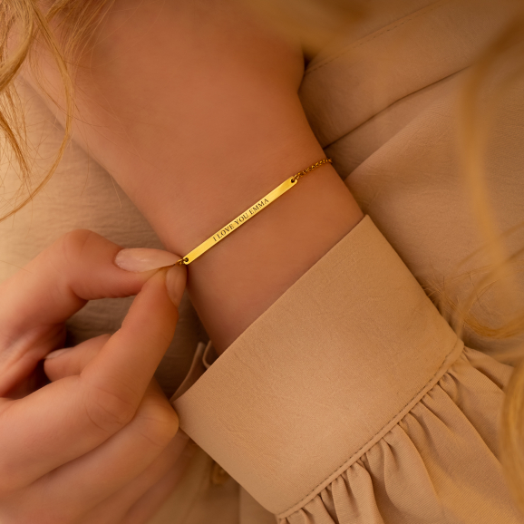 Minimalistische armband bar graveerbaar om de pols van model in het goudkleurig