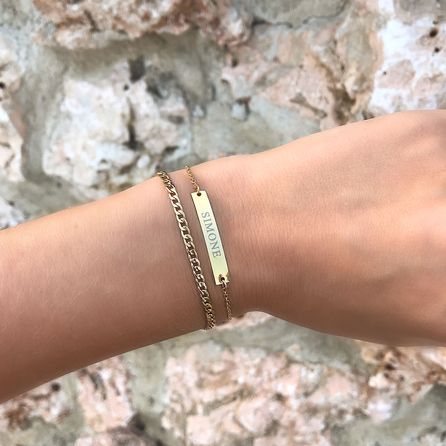 Gouden armband met gravering om de pols met bar