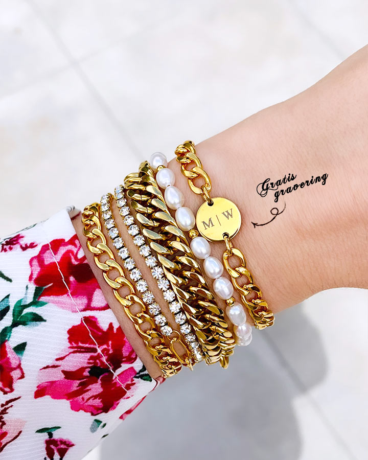 Gouden chunky initial armband om pols bij vrouw