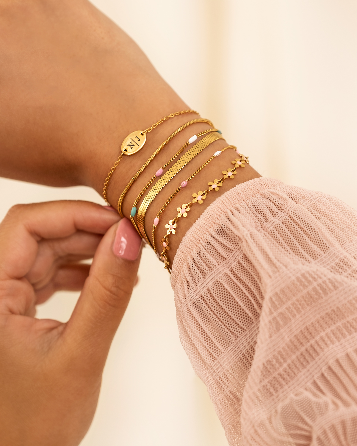 Gouden armband met bloemetjes met roze details