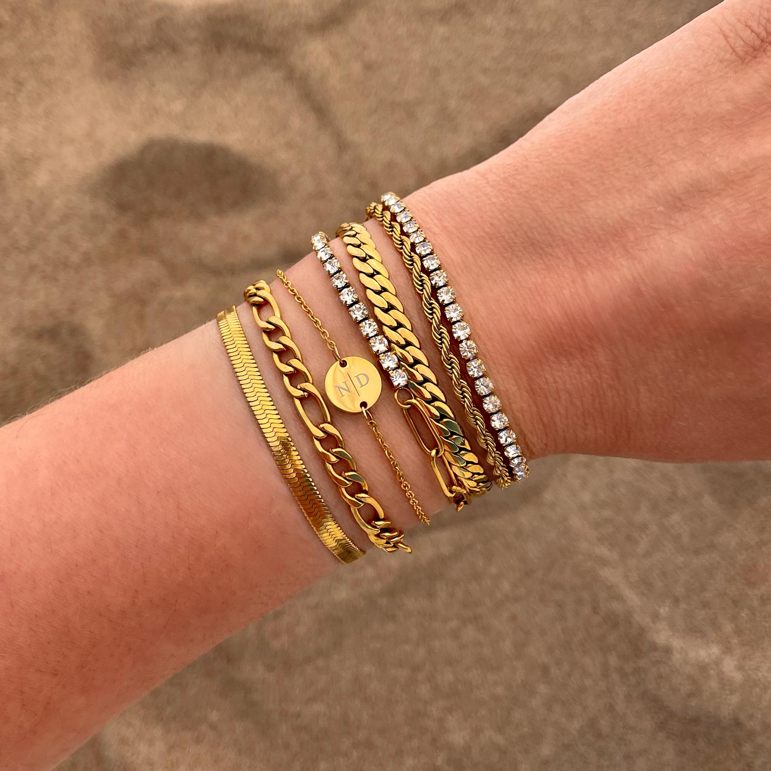 trendy combinatie van gouden armbanden om pols