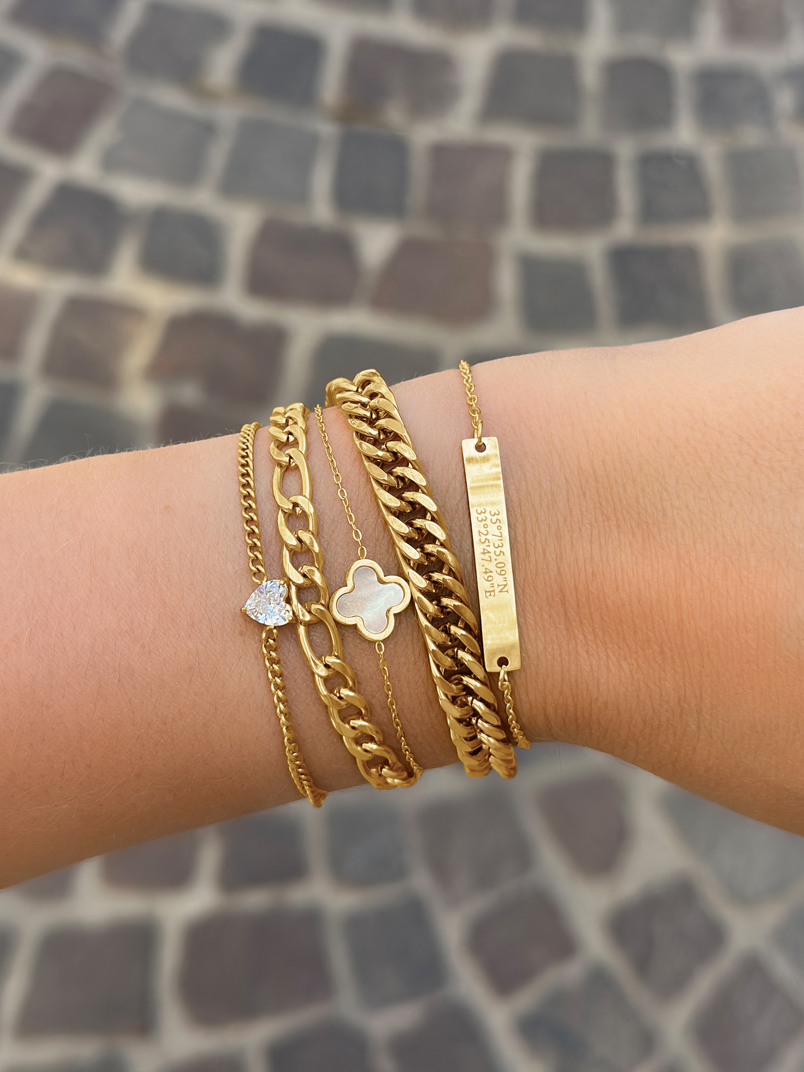 Vrouw draagt gouden armbanden combinatie om haar pols