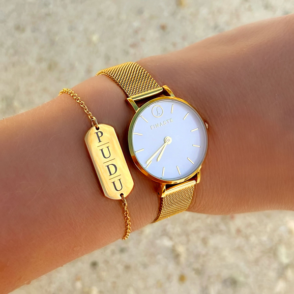 Gouden armband met vier initialen en gouden horloge om pols