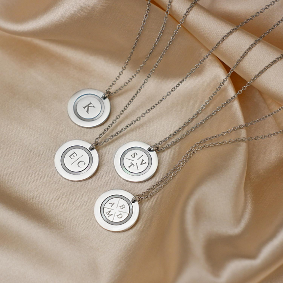Zilveren initialen kettingen met parelmoer op satijn