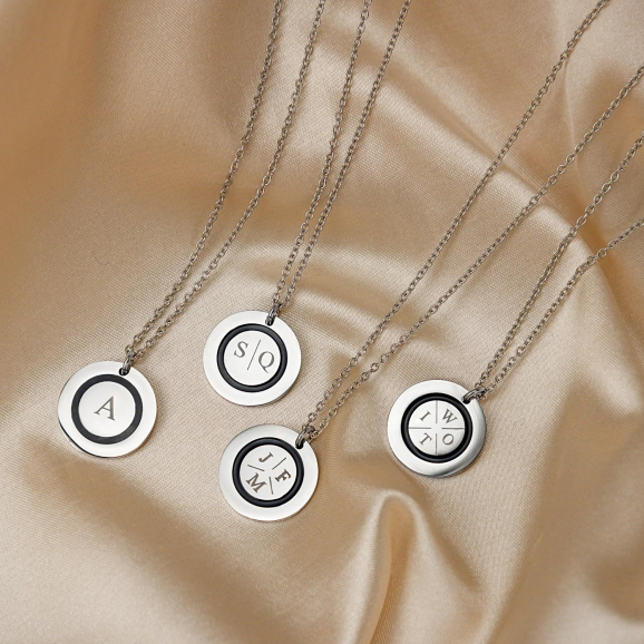 Vier kettingen met initialen in de kleur zilver