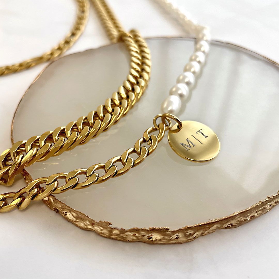 gouden chain armbanden met parels en gravering op plateau