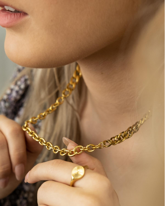 Het model draagt de goudkleurige drie chain mix om haar hals