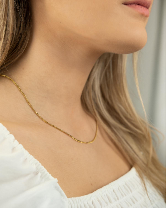 Mooie minimalistische schakelkettinkje in het goud kleurig om de hals van het model