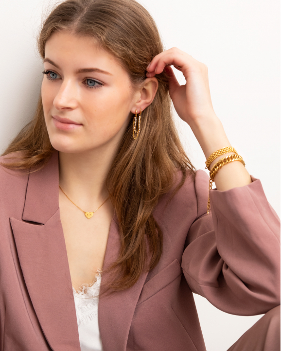 gouden sieraden op model met roze blazer