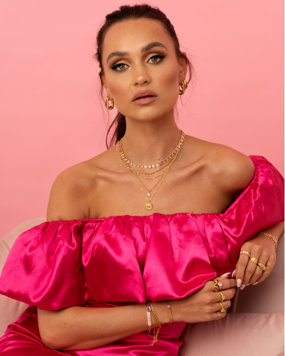 Model draagt mix van roze en gouden sieraden
