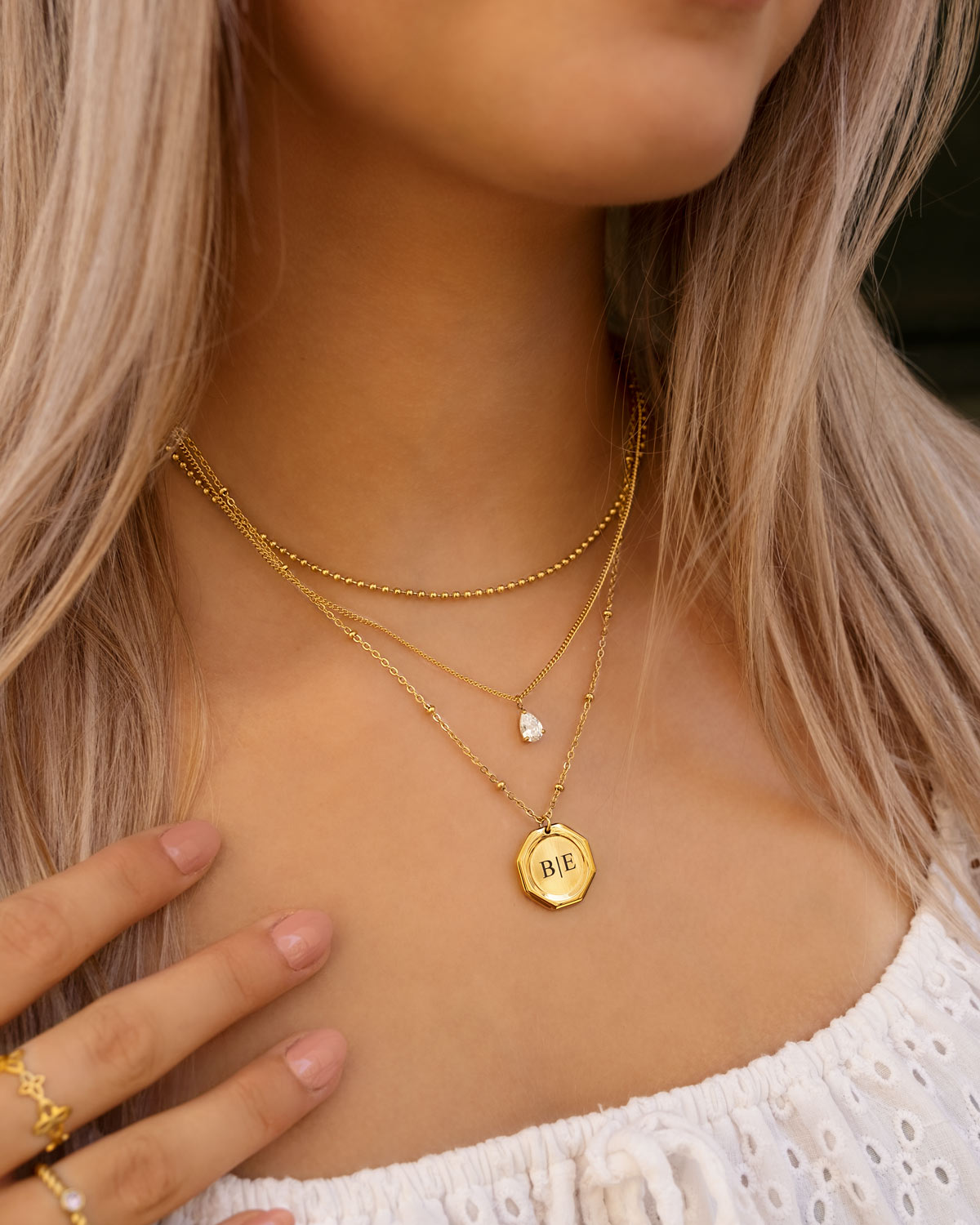 model draagt gouden bolletjes ketting