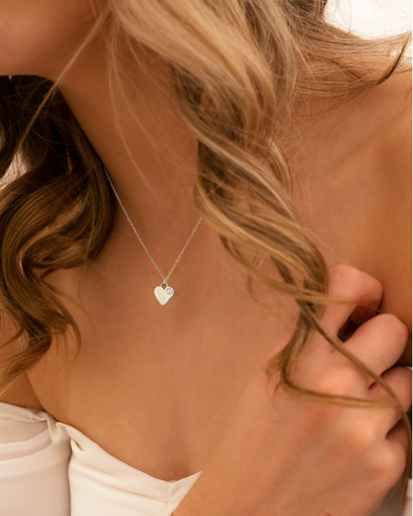 Model draagt Heart & pearl necklace om hals