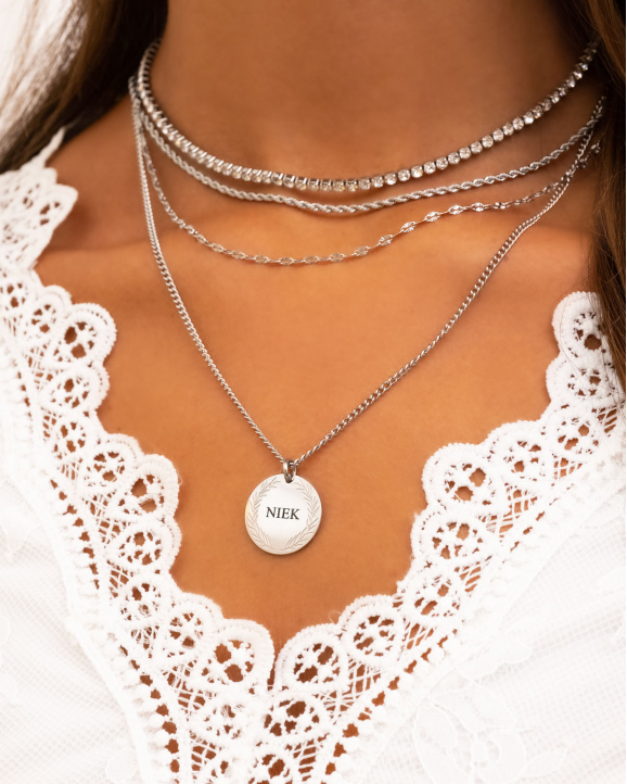 Vrouw draagt necklace layer met mix van zilveren kettingen