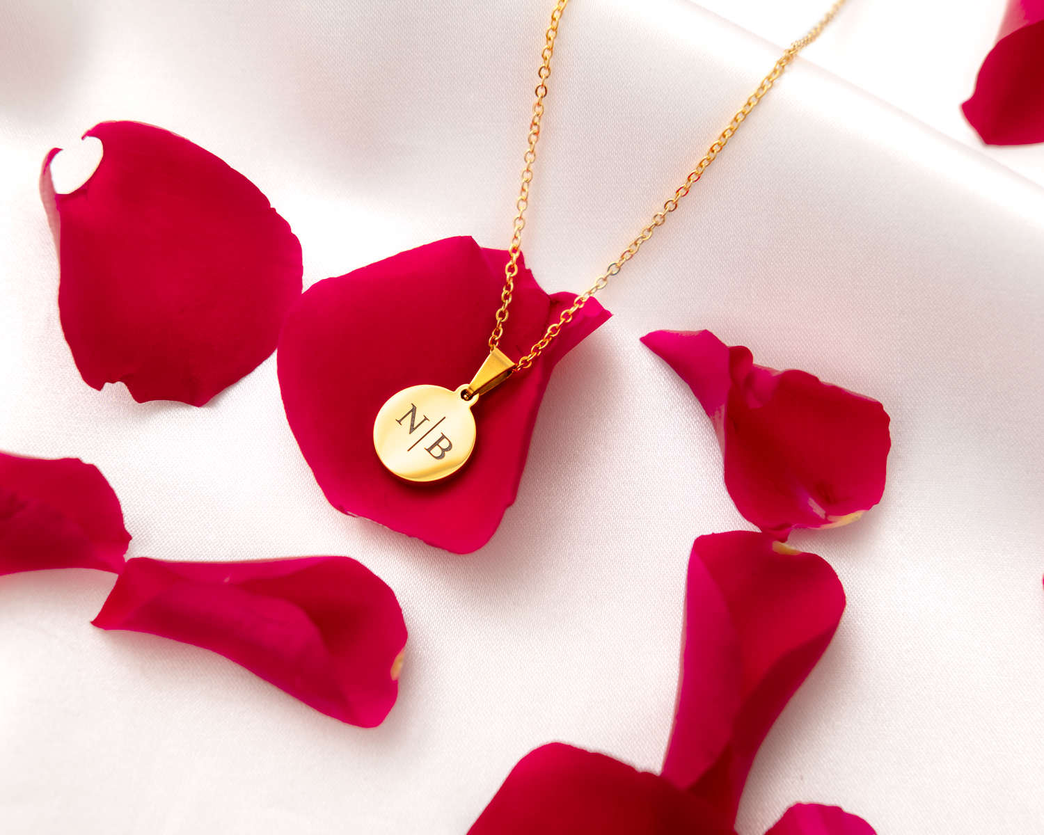 gouden ketting met coin graveerbaar op roze blaadjes