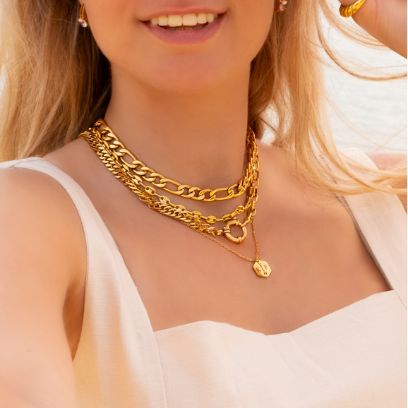 Model draagt mooie gouden kettingen om hals