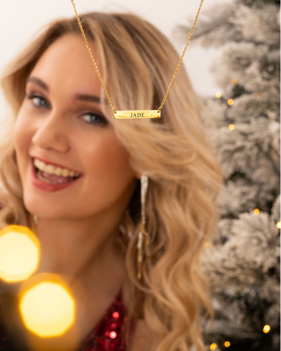Gouden initial ketting met model bij kerstboom