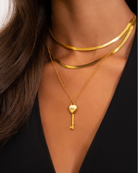Model draagt necklace layer met gouden kettingen