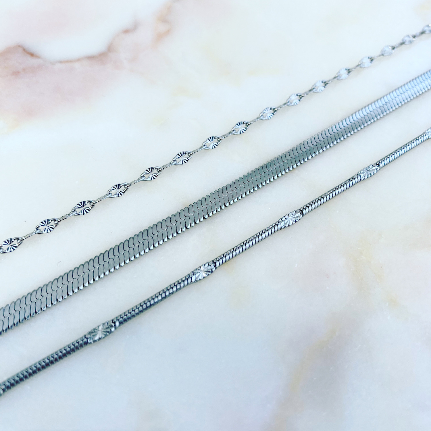 Stainless steel choker kettingen op marmeren ondergrond