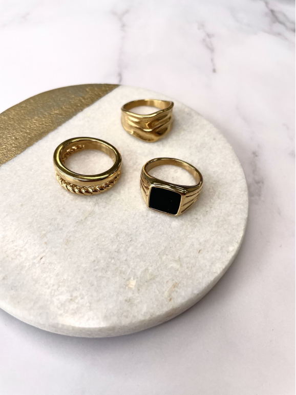 Mooie gouden chunky ringen op een marmeren achtergrond