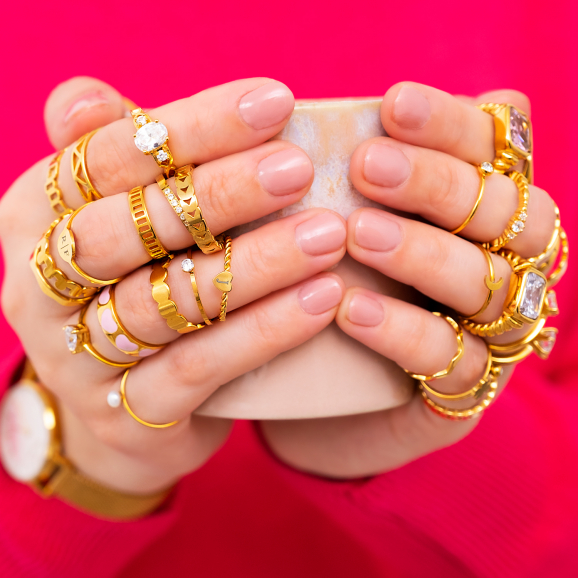 Verschillende gouden ringen om handen van model