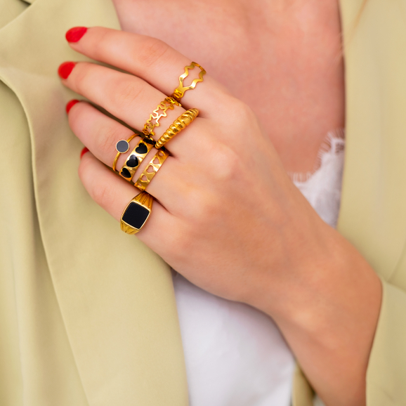 Model draagt mix van gouden ringen om handen