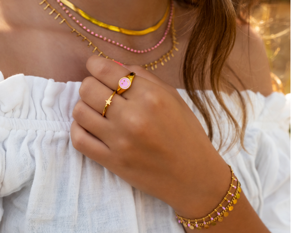 Model draagt mix van gouden en roze sieraden