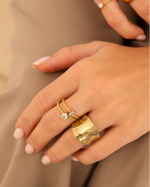 Model draagt gouden ringen om vingers