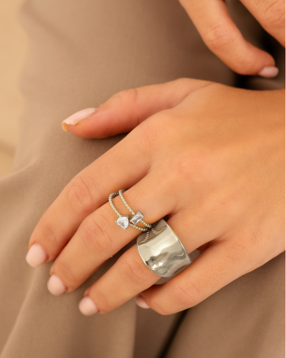 model draagt zilveren ringen om hand