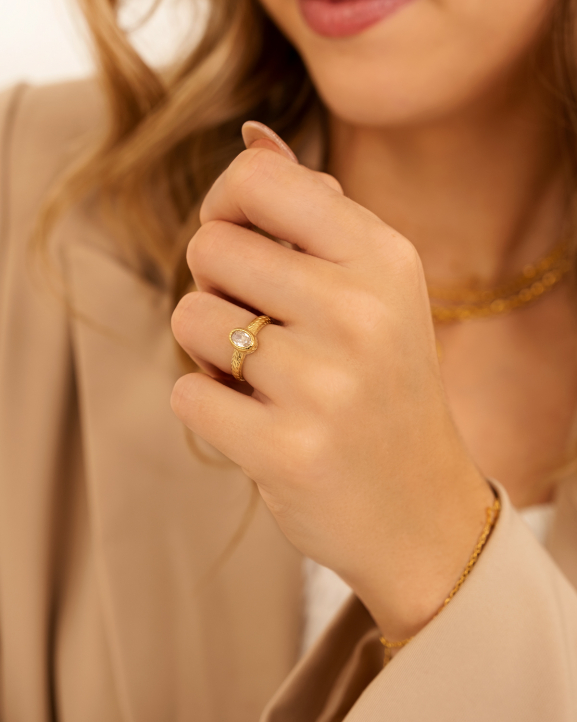 Model draagt gouden ring met steen