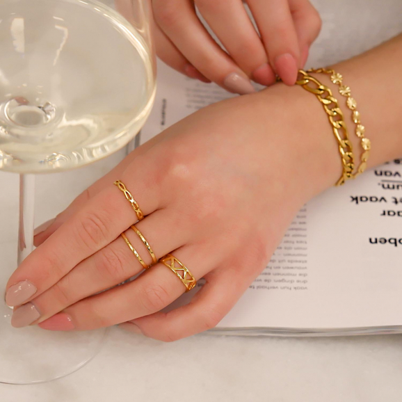 Mooie gouden ringen om de hand met een glas wijn