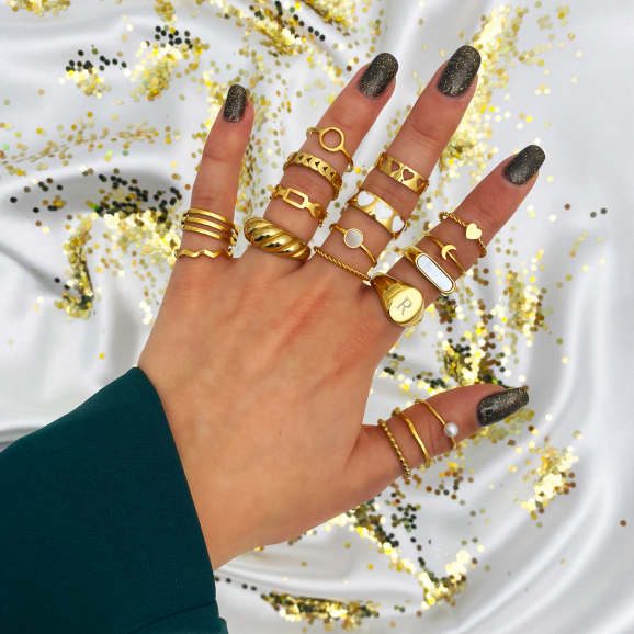 gouden ringen met detail zwart om vingers vrouw met glitter achtergrond