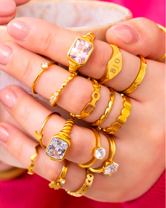 Model draagt goudkleurige ringen om hand
