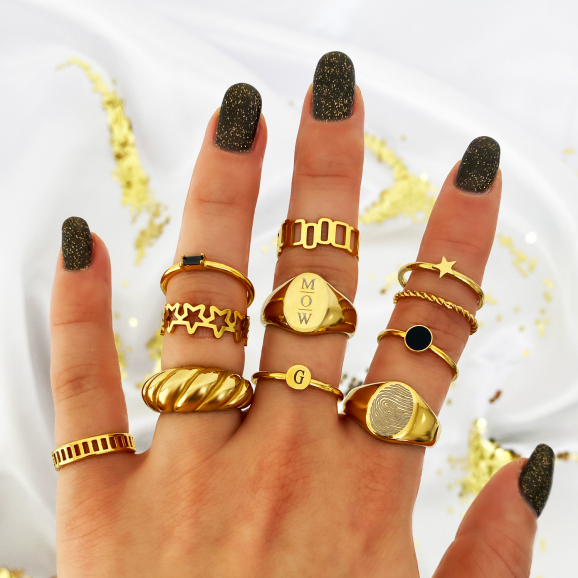 gouden ringen om vingers van vrouw met witte satijnen achtergrond