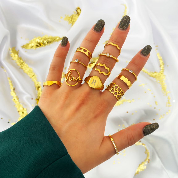 goud kleurige ringen om vingers vrouw met satijnen achtergrond