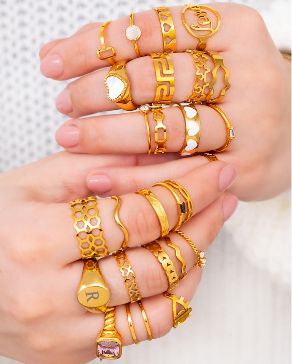 Model draagt combinatie van goudkleurige ringen