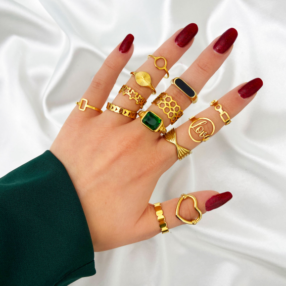 Goudkleurige ringen mix om hand van model