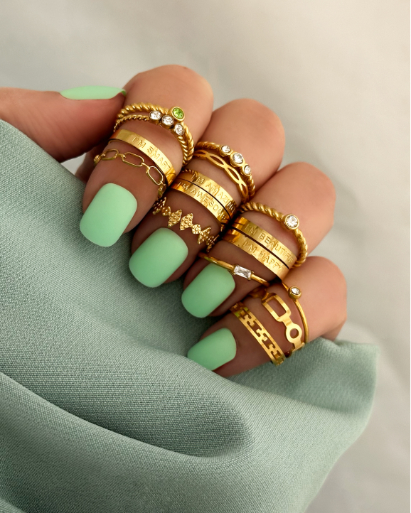 Goudkleurige ringen met groene nagels