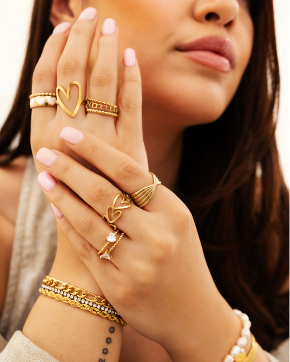 Model draagt gouden ringen om hand