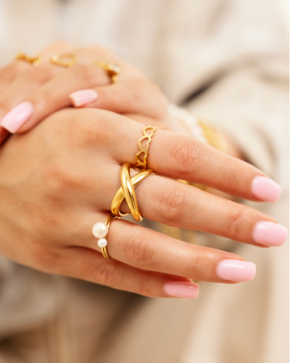 Model draagt gouden ringen om vingers 
