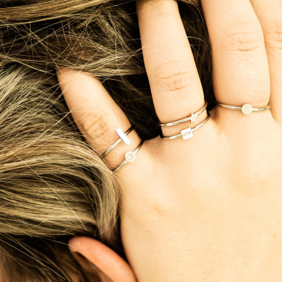 Minimalistische zilveren ringen bij vrouw met blond haar
